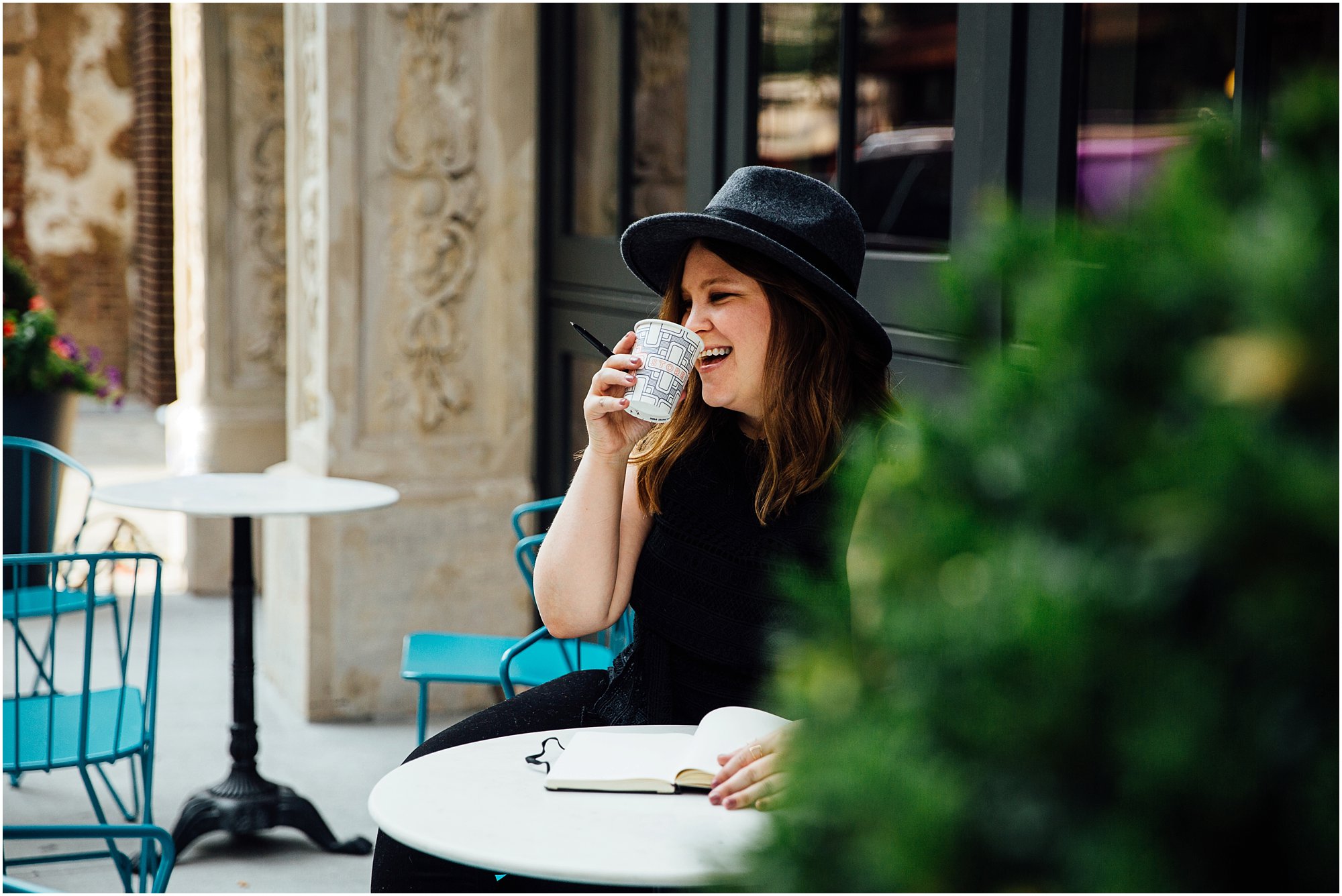 Lady sipping coffee at table outside of Dream Hotel in Nashville, TN.