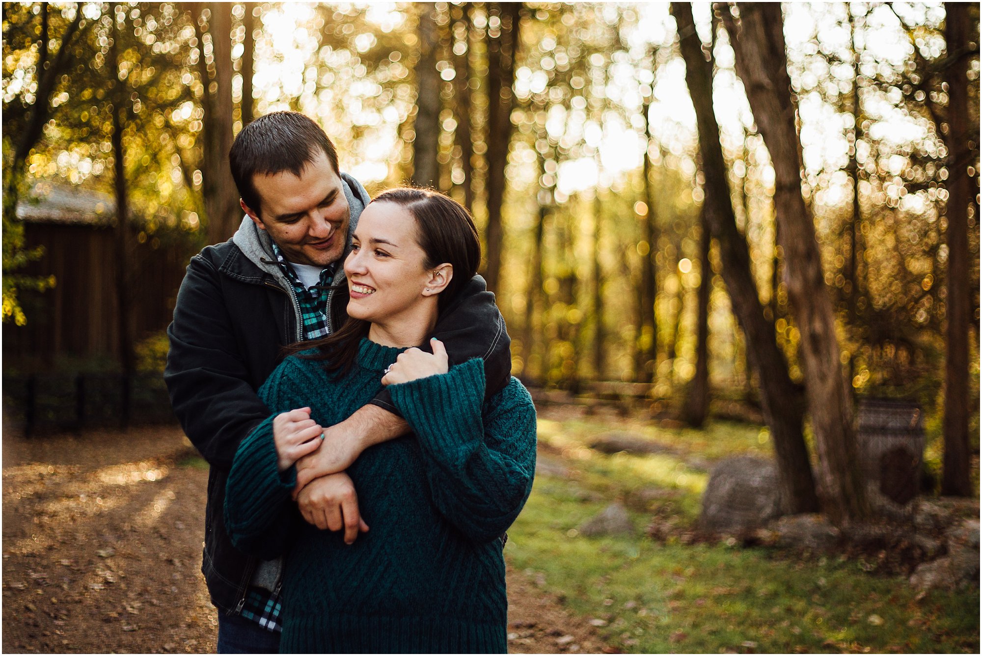 Engaged couple embracing on gravel path during engagement session