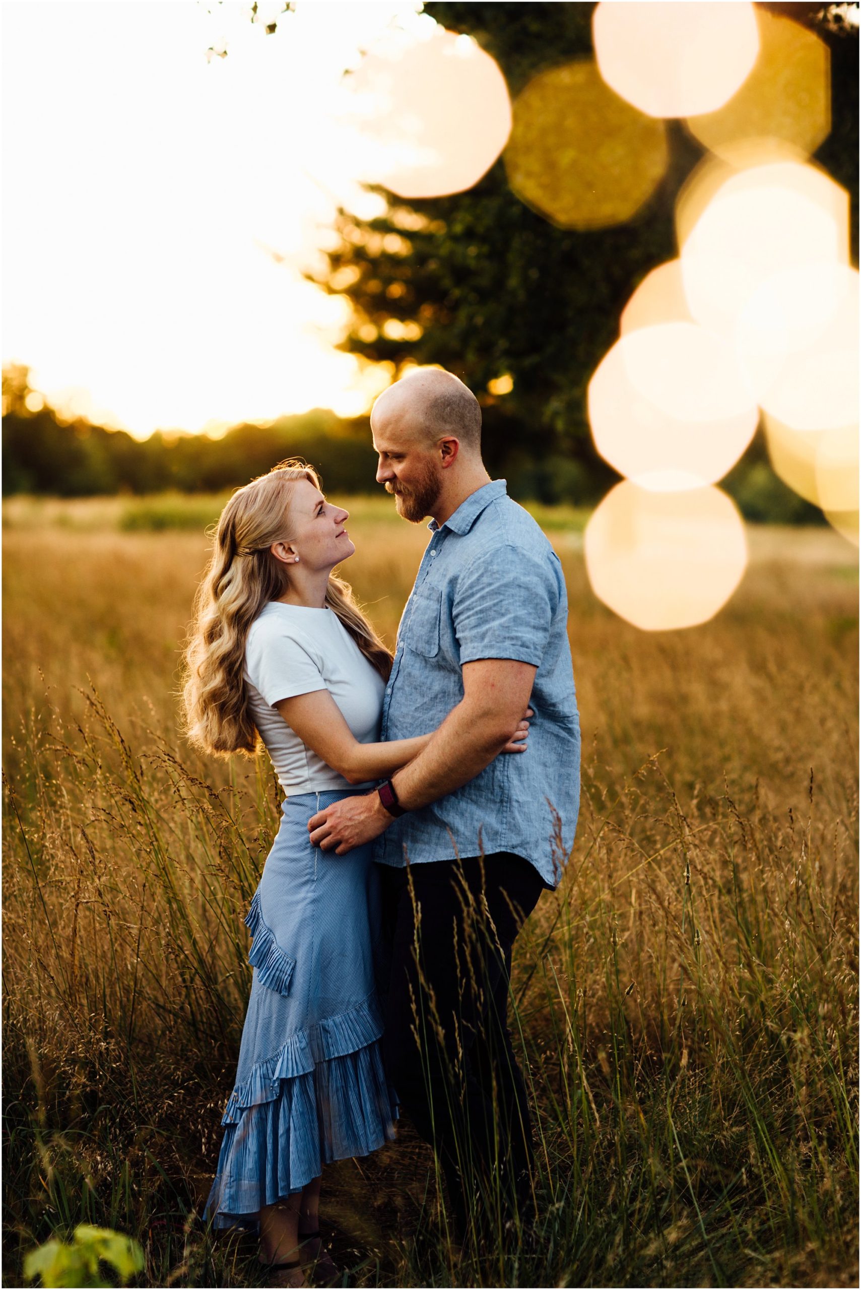 Beautiful couple embracing with bokeh lights and golden sunset