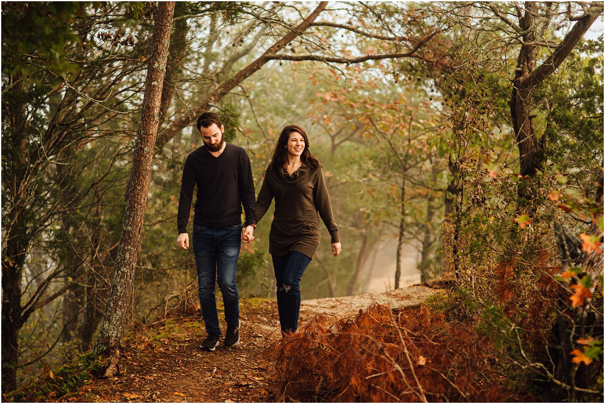 Engaged couple holding hands and walking down path at Narrows of the Harpeth