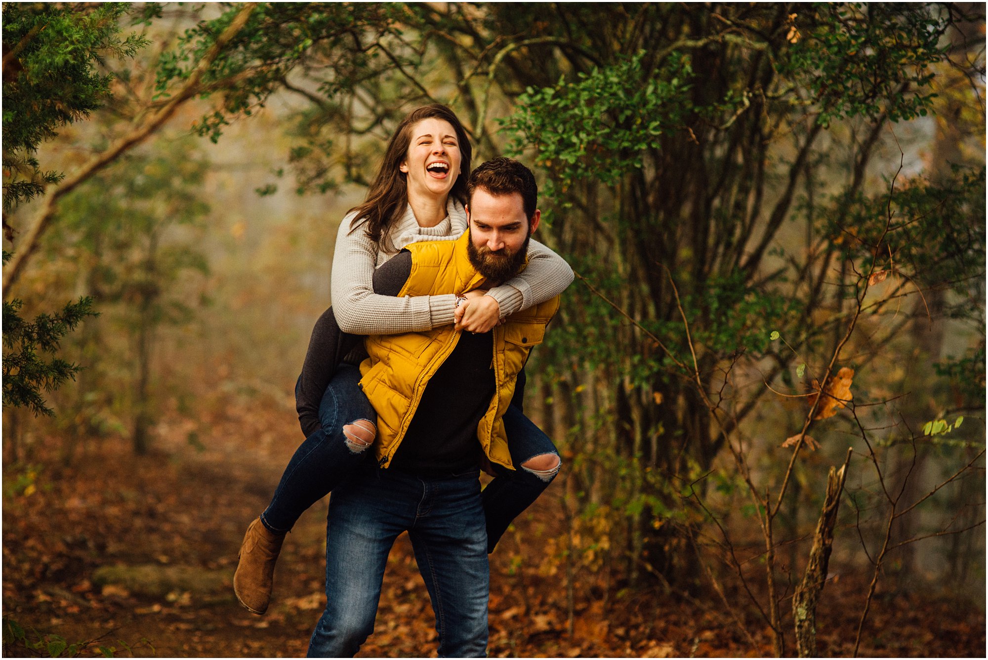 Couple laughing as guy gives girl piggy back ride on a trail in Kingston Springs, Tennessee.