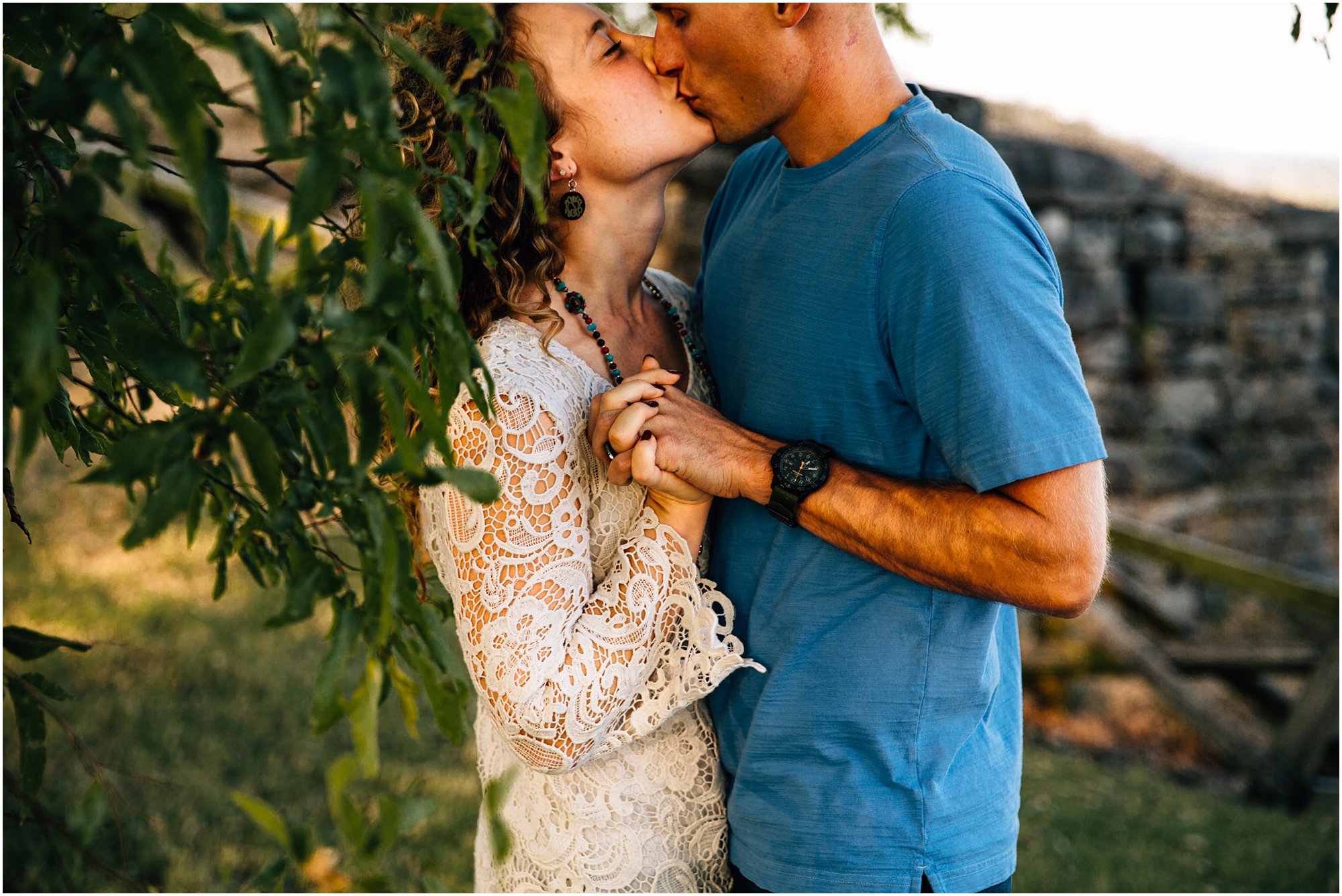 Engaged couple stealing kisses at Fort Negley