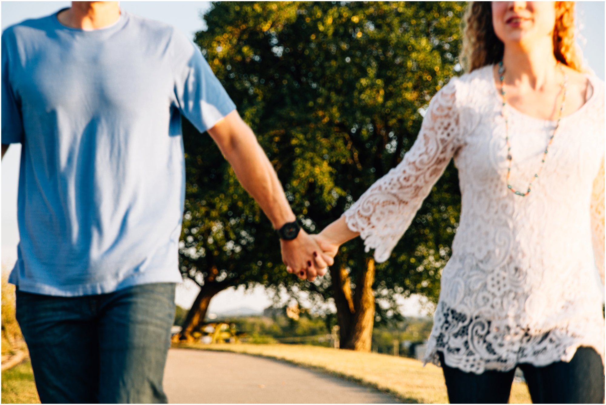 Engaged couple running towards camera while holding hands