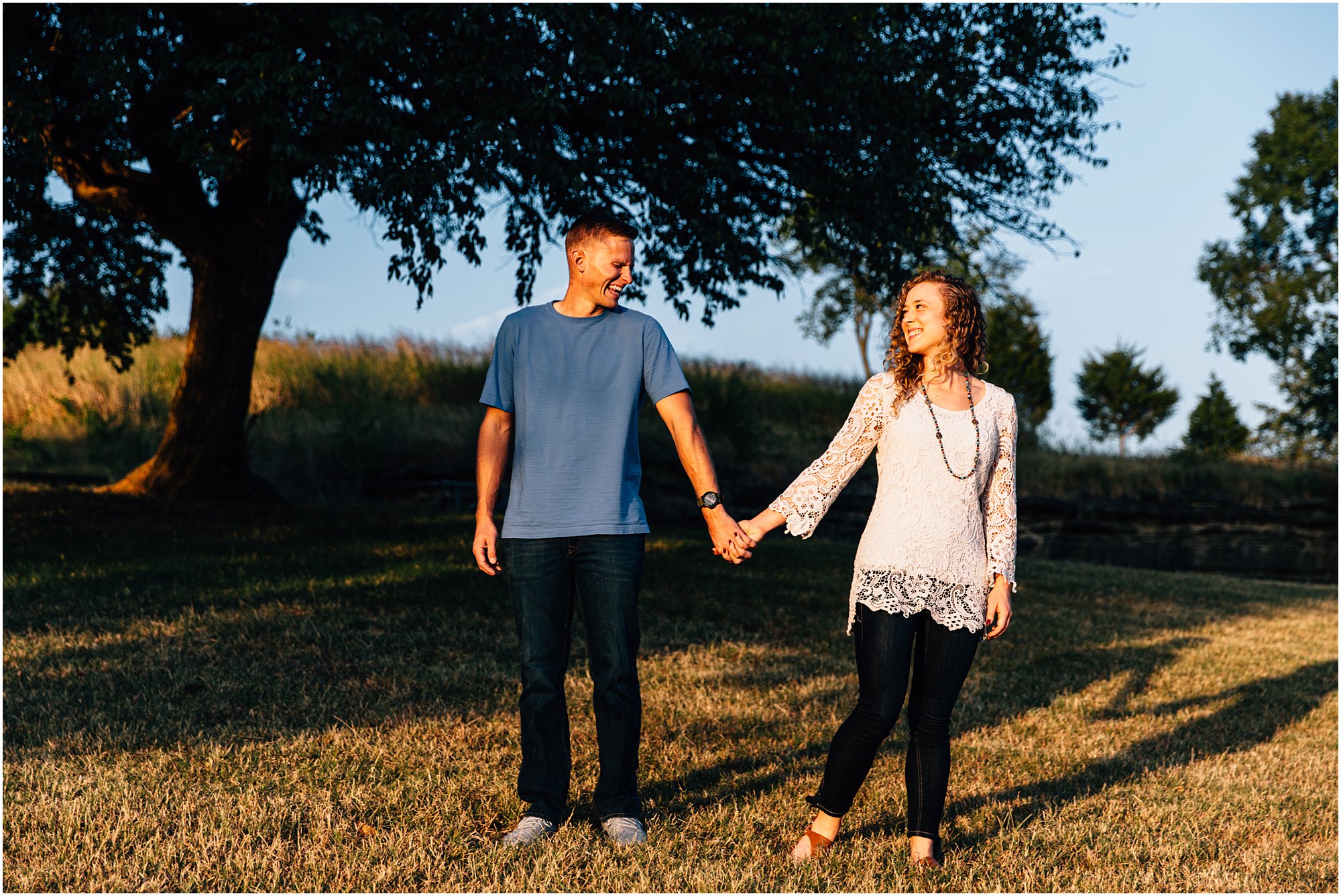Nashville couple holding hands at golden hour and laughing with each other