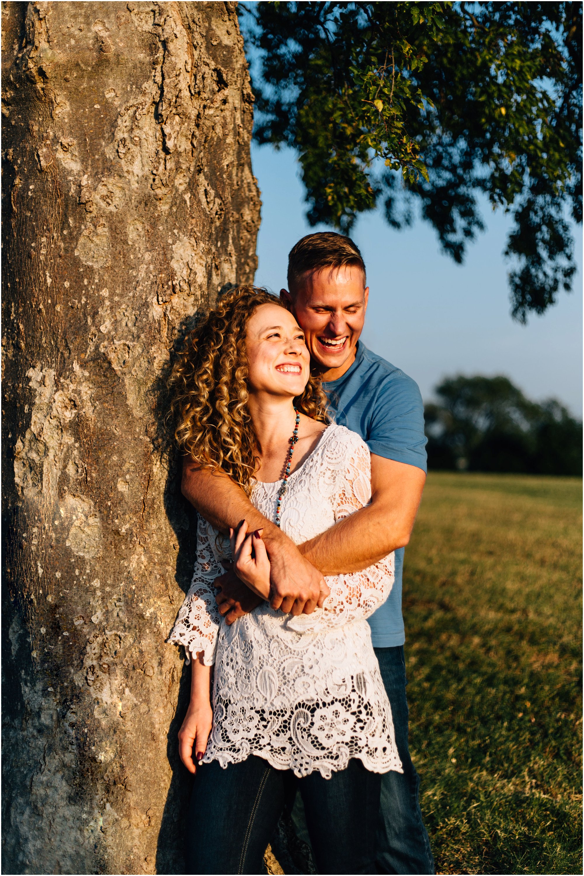 Newly engaged couple hugging and leaning against tree at Nashville's Fort Negley