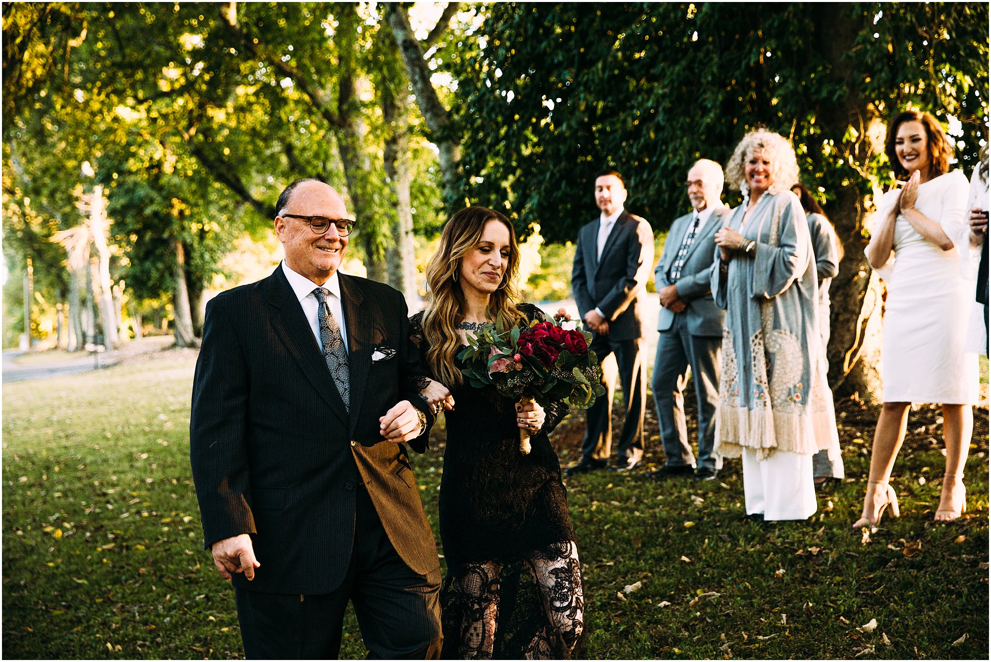 Father walking his daughter down the aisle during fall, backyard ceremony