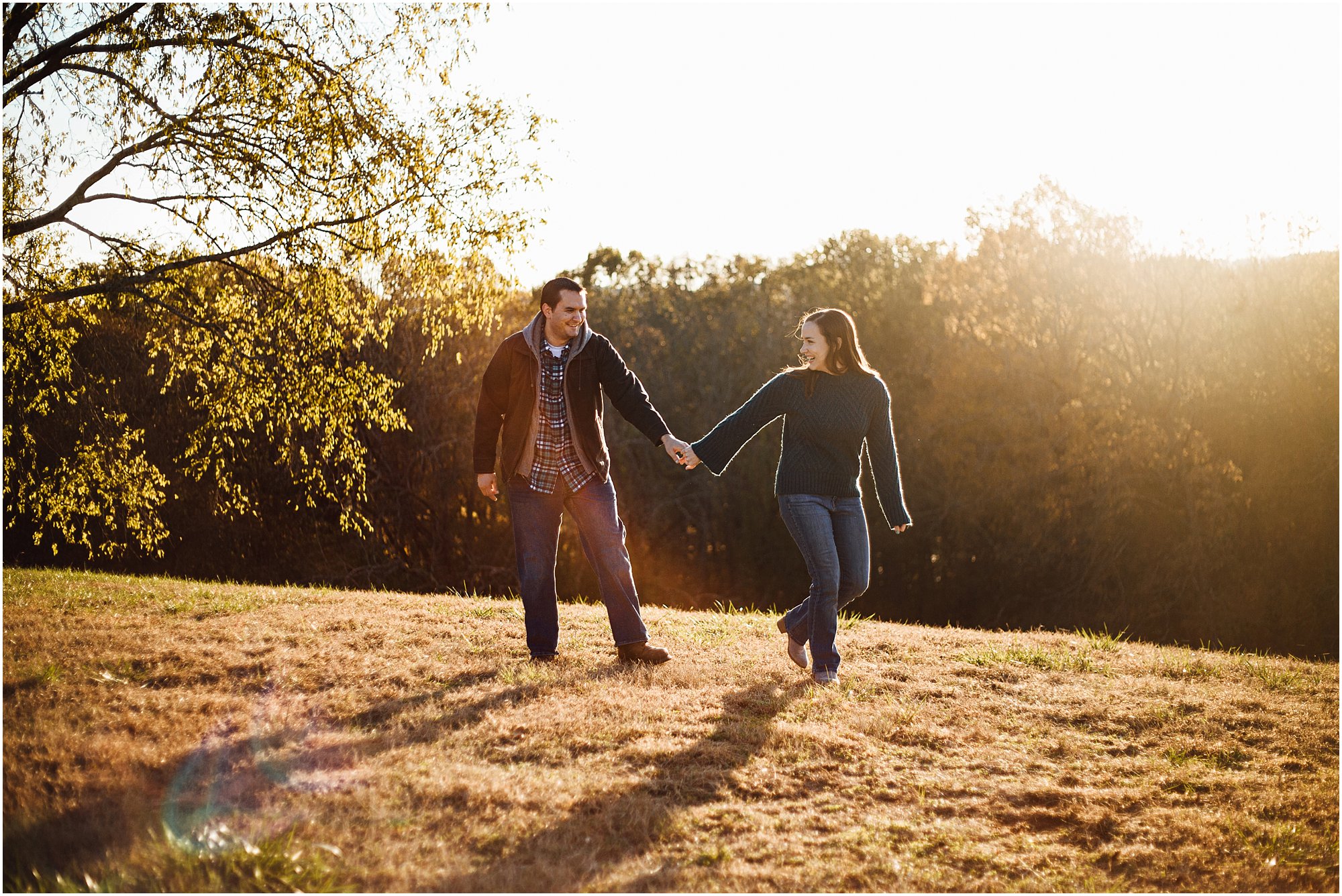 Engaged couple walking on hill together during golden hour at Arrington Vineyards.