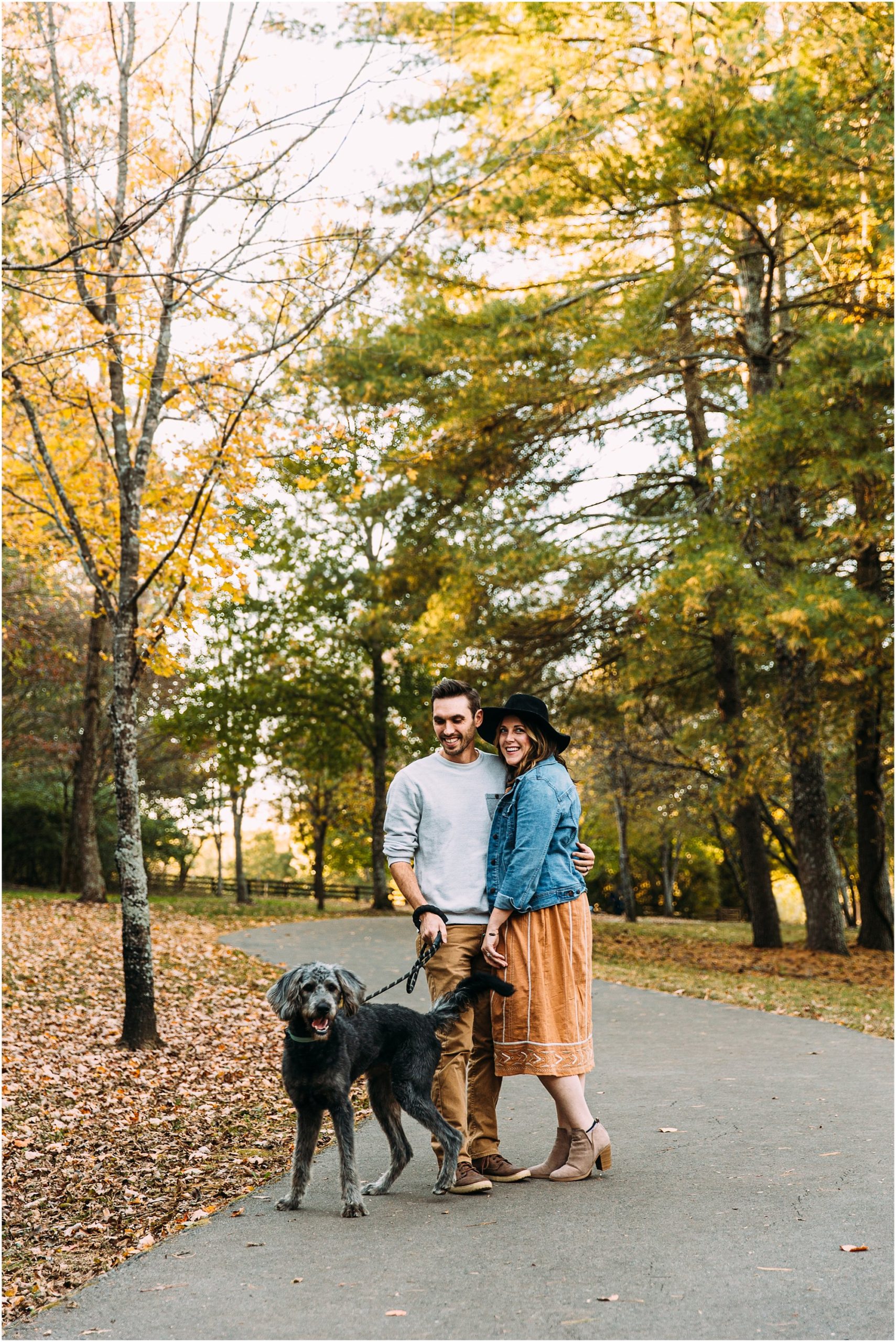 Cute couple with their dog walking through a Brentwood, TN park