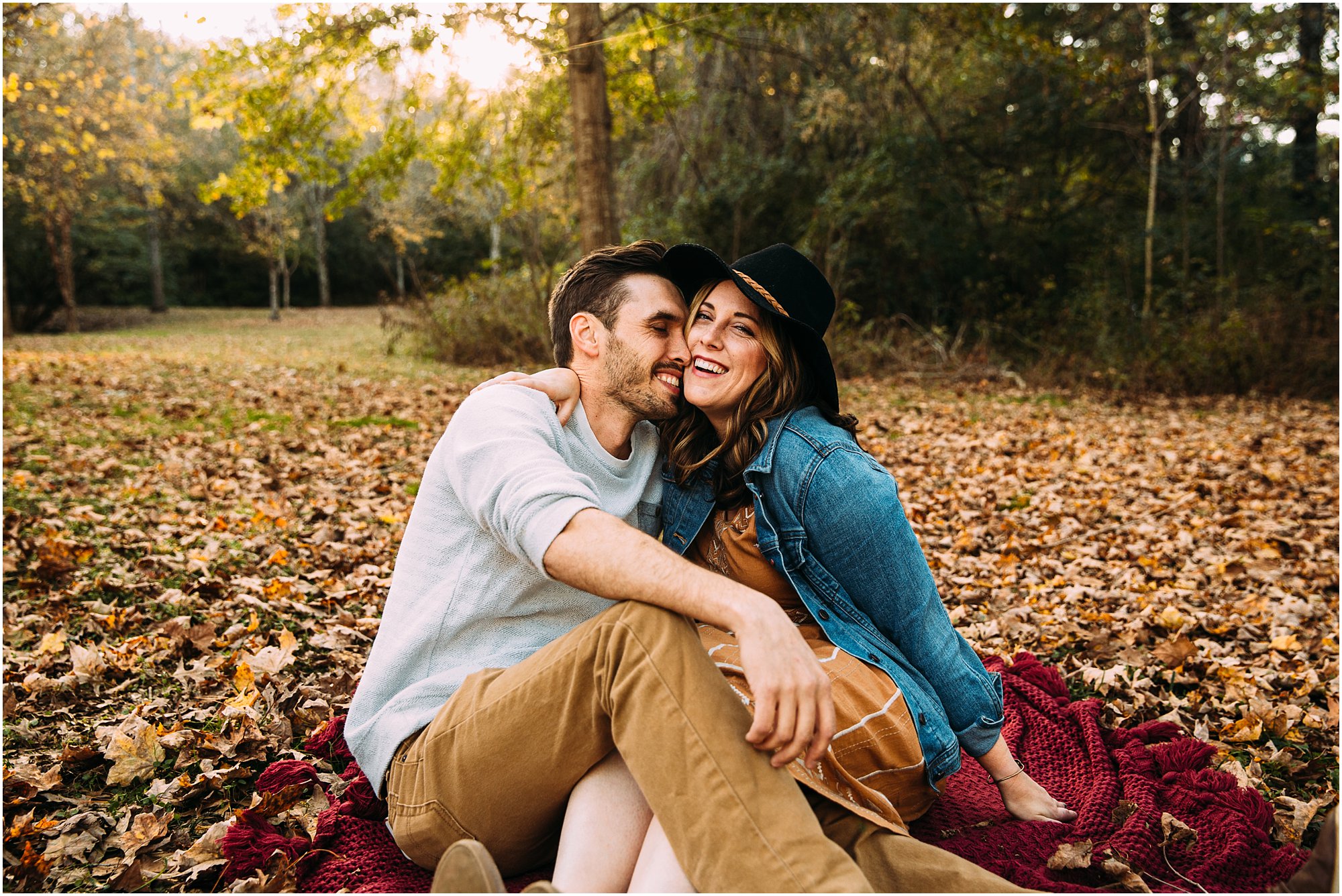 Couple on cozy blanket surrounded by orange leaves in Brentwood