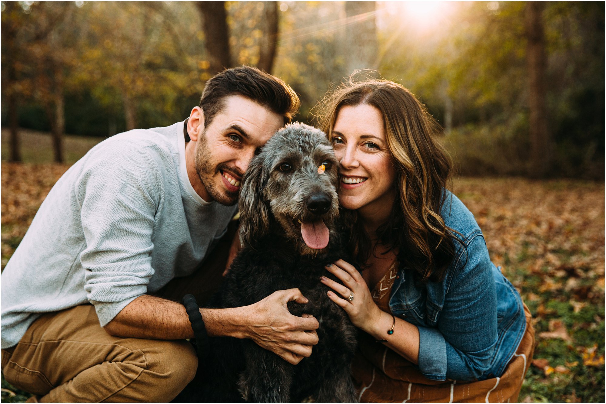 Couple snuggling their faces into dog's fur during photoshoot