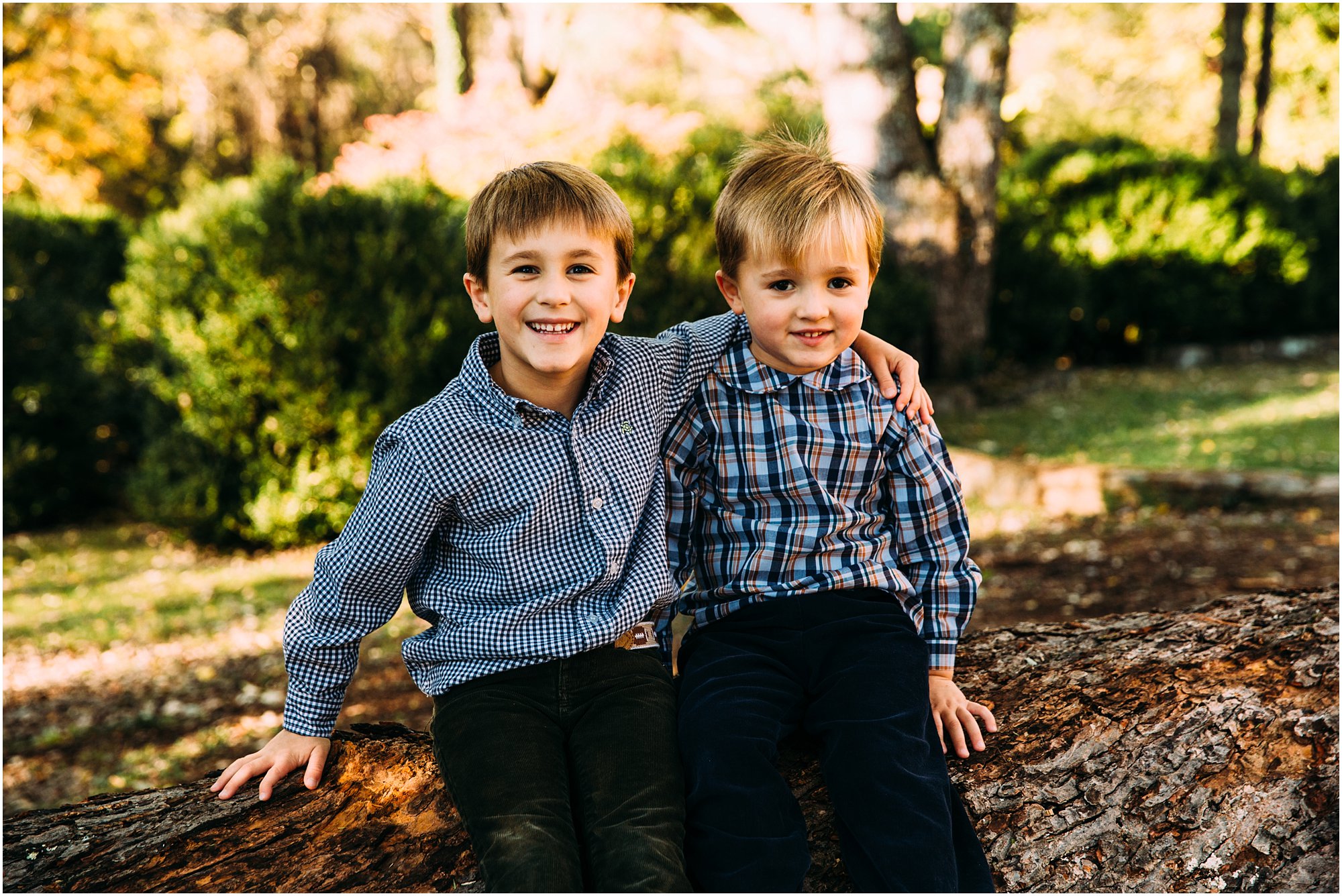 Brothers hugging and smiling at camera during family session