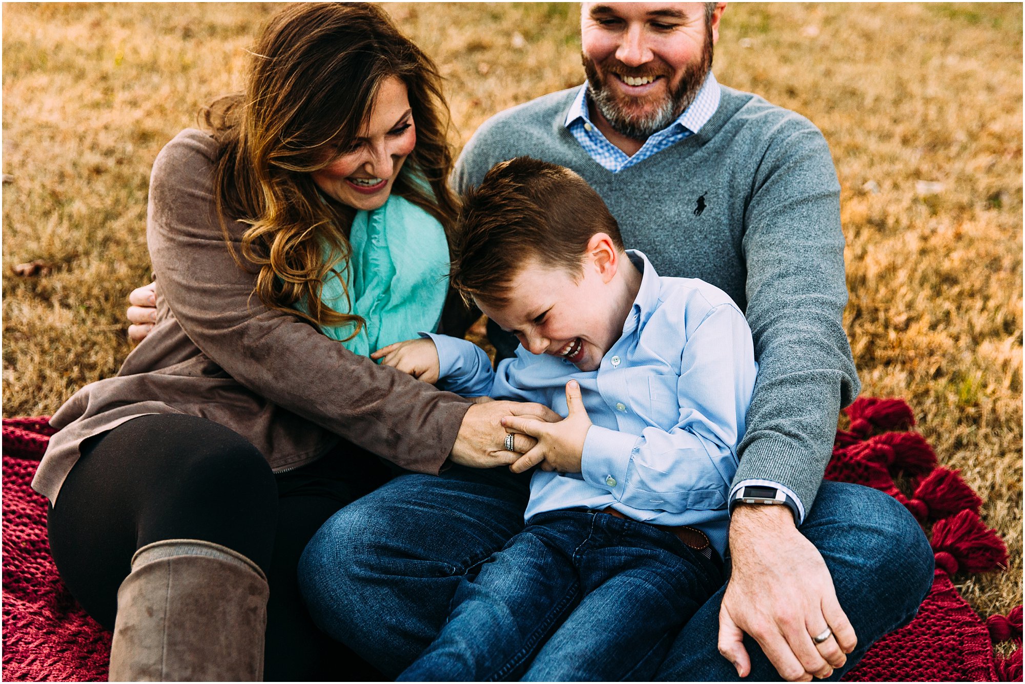 Mom tickling her son as they all laugh together during fall mini session
