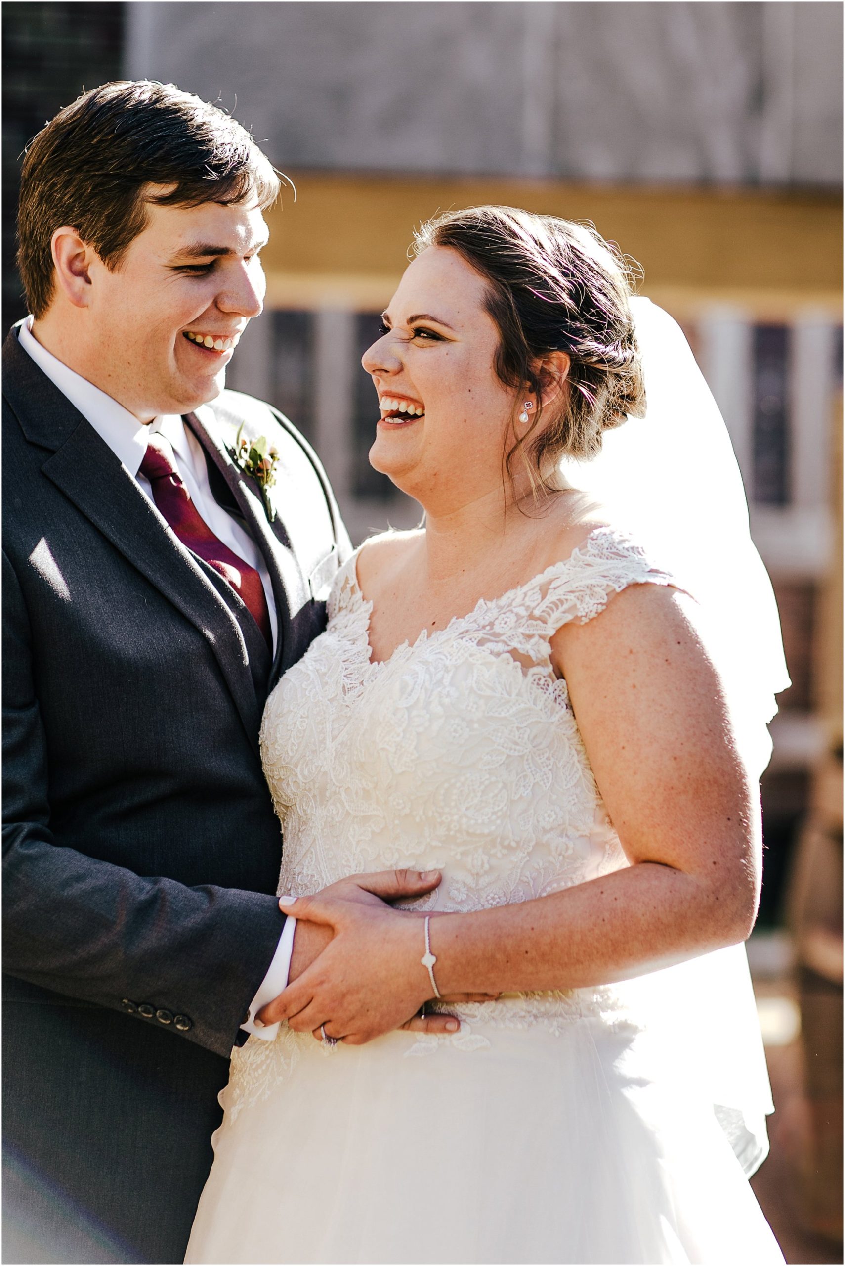 Adorable wedding couple embracing and laughing together outside of St. Luke's church in Memphis, Tn