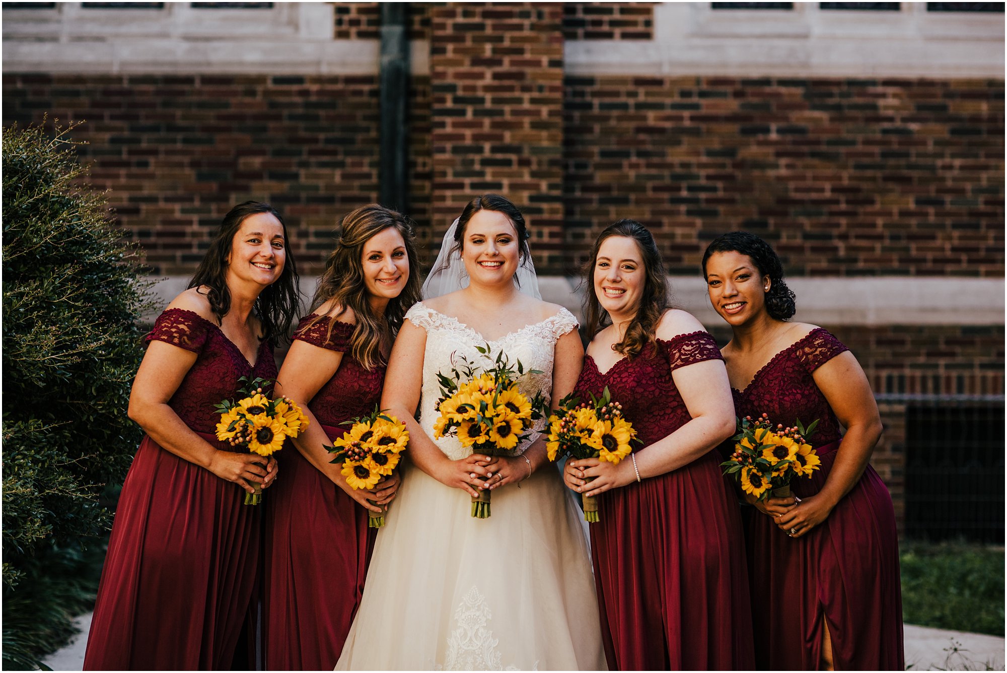 Bride Lauren with her bridesmaids smiling together outside of St. Luke's Church in Memphis
