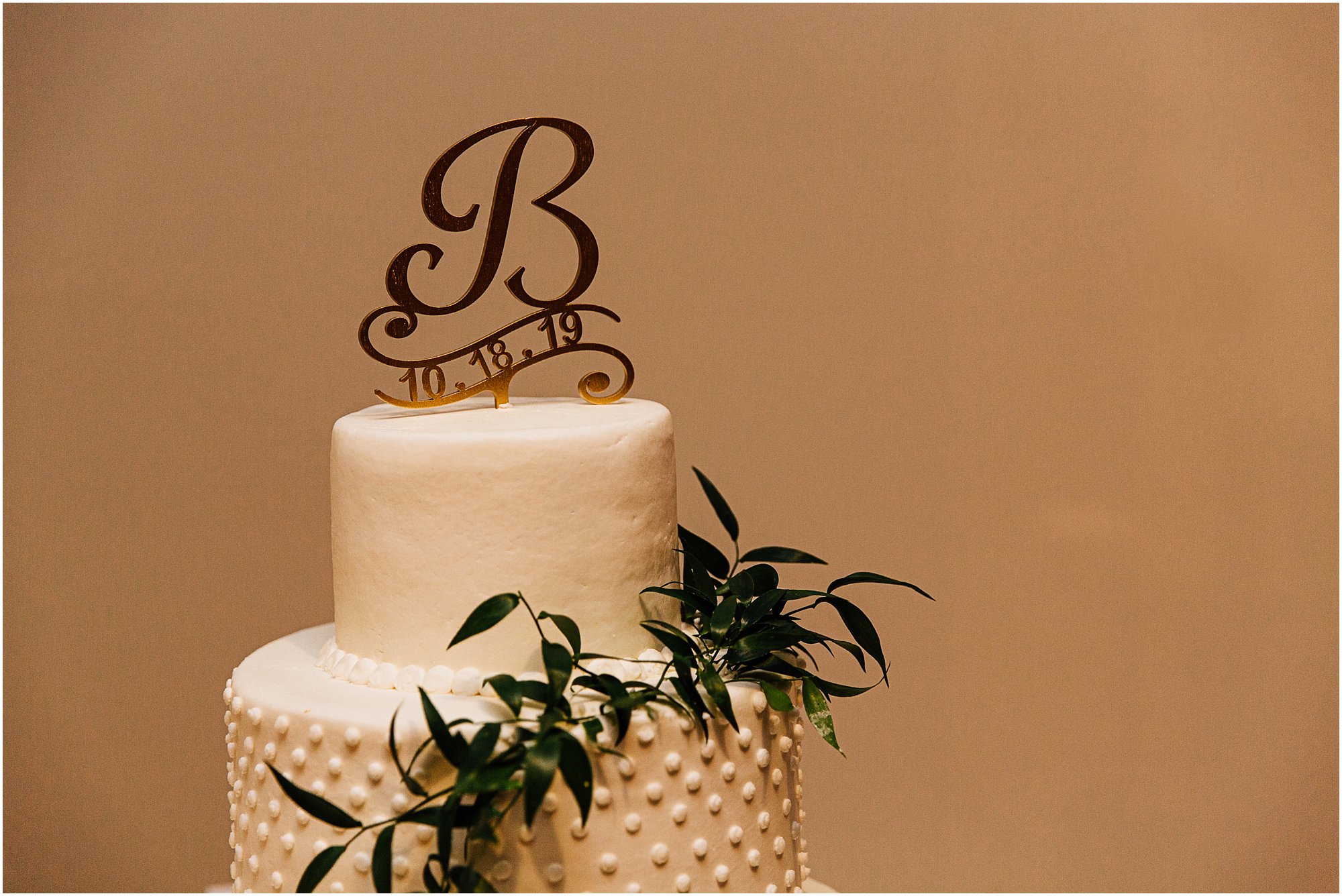 Beautiful wedding cake with gold letter B topper