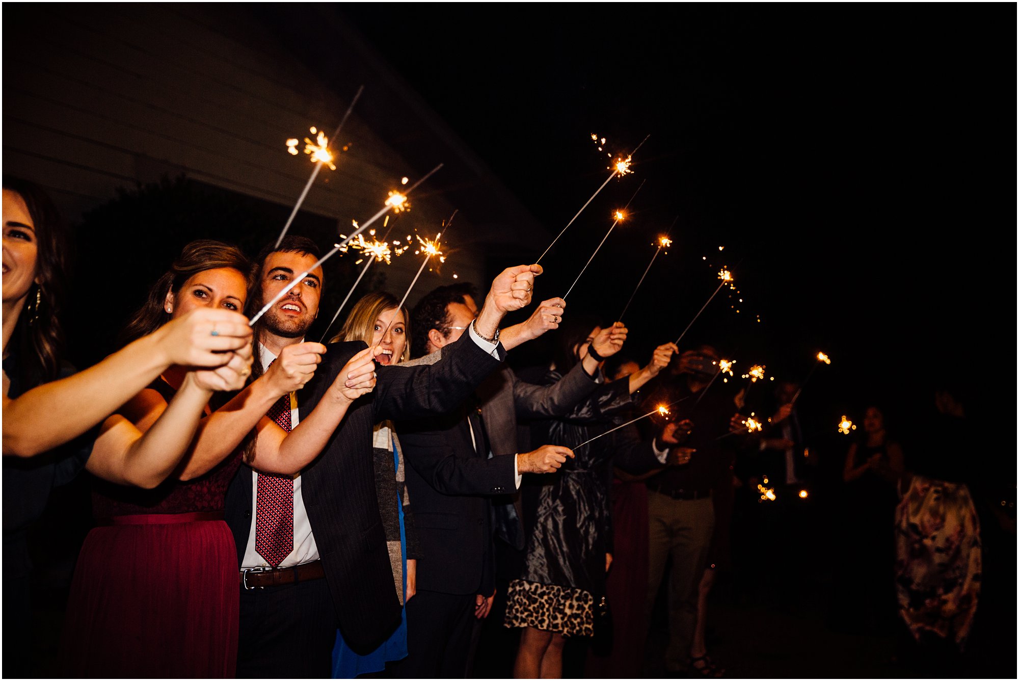 Guests excitedly holding their sparklers during couples' exit