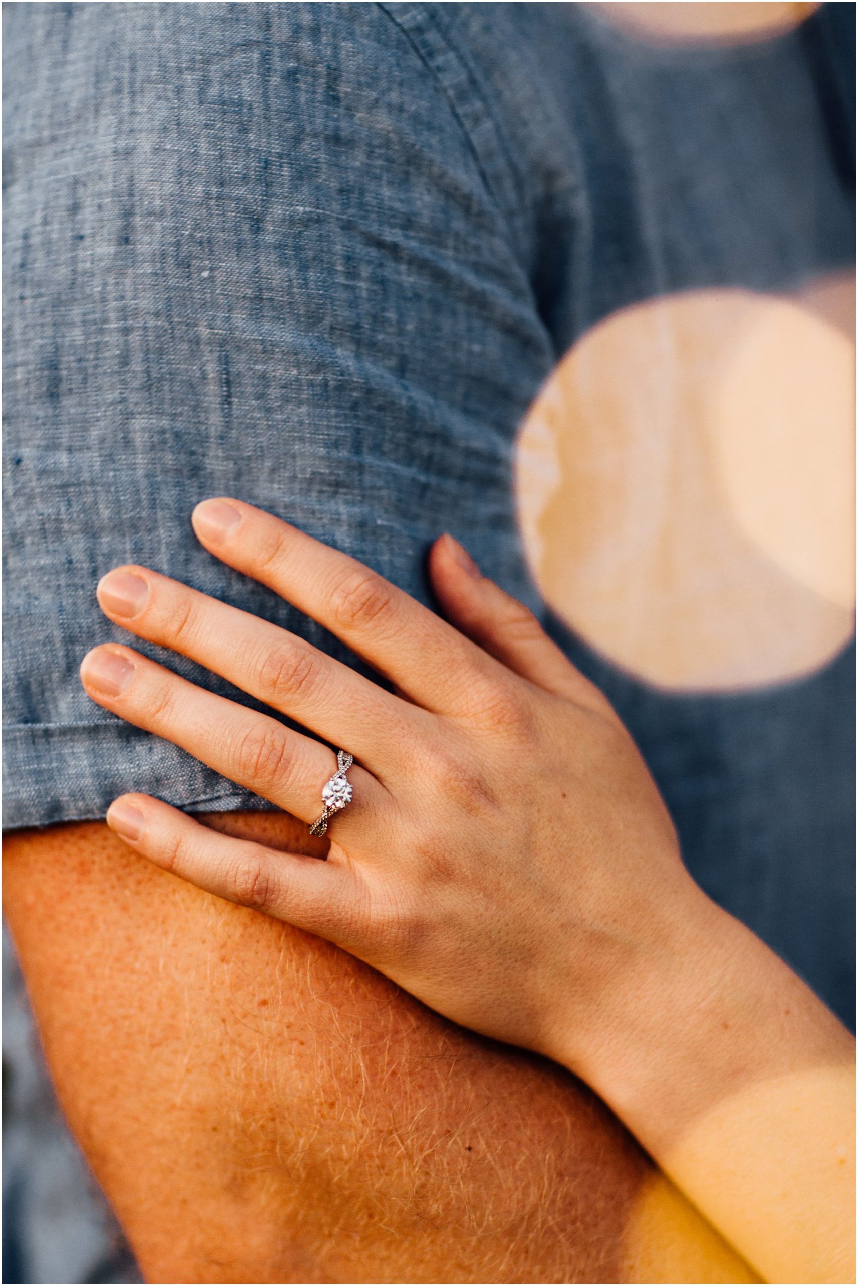 Beautiful engagement ring resting on fiancé's arm